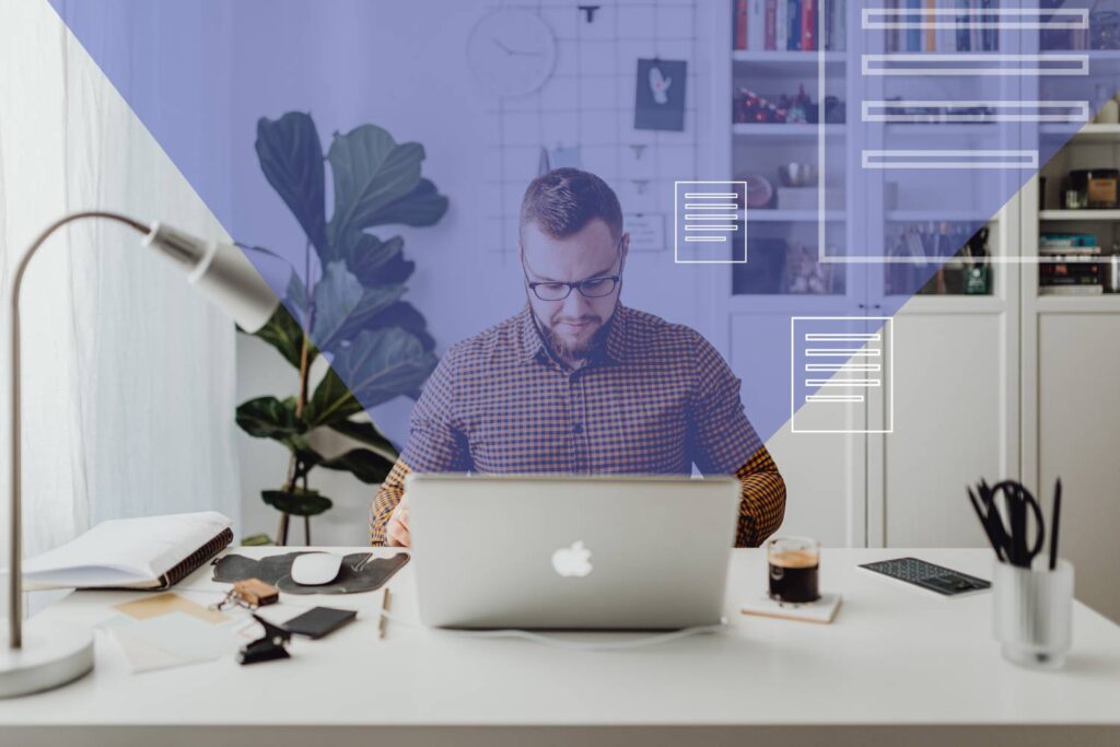 Mężczyzna siedzi przy biurku i pracuje na laptopie