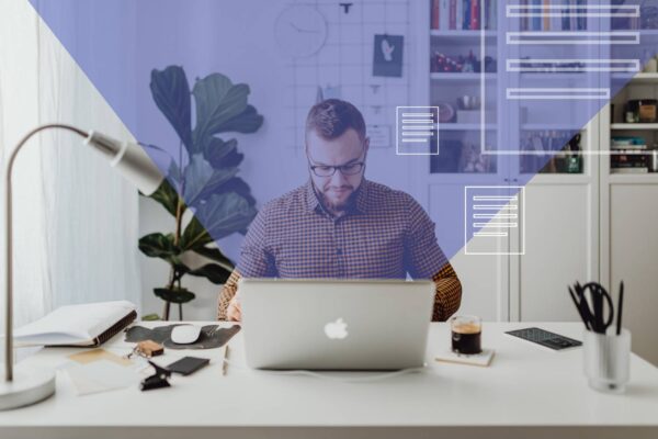 Mężczyzna siedzi przy biurku i pracuje na laptopie