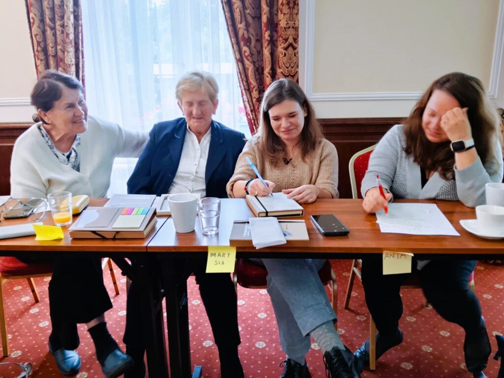 zdjecie przedstawia osoby siedzace przy stole sali szkoleniowej i uczestniczące w szkoleniu